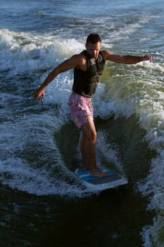 Young man wake surfing in lake.