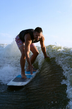 Man wakesurfing behind wakeboard boat.