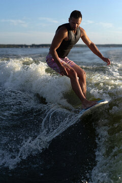 Young man wake surfing in lake against clear sky.