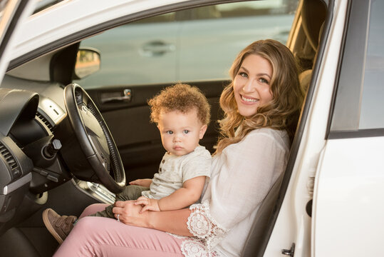 Mother and son sitting in drivers seat of car