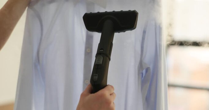 Woman uses steam iron removing wrinkles and creases from shirt slow motion. Device for maintaining well-pressed clothing without effort