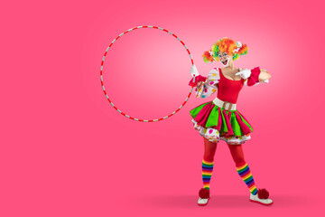 Funny female clown pointing at hula hoop blank template copy spase for advertising, posters, greetings, invitations. Entertainer as Joker in a suit and wig, with clown whiteface makeup