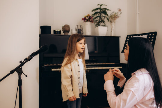 Vocal school. a woman teaches a little girl to sing