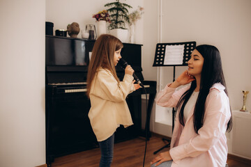 A little girl learns to sing with her teacher