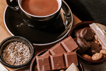 Chocolate chip cookies, dark and white chocolate bar, small bowl of oatmeal and nuts. International Chocolate Day.
