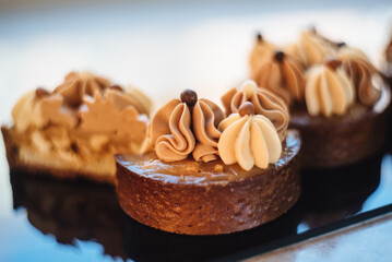 Shortbread tartlets with salted caramel and nuts. Sweet chocolate cakes. Modern mini desserts for candy bars, parties. Selective focus