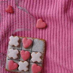 Tic-tac-toe game. Gingerbread cookies for Valentine's Day. Romantic vibrant pink love background....