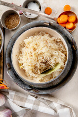 Winter salad on wooden light background. Homemade sauerkraut cabbage withcarrot. Tasty