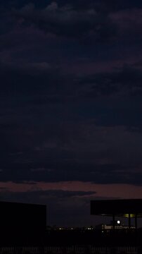 Vertical video - Timelapse of rolling storm clouds with visible lightning