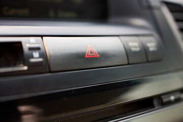 Obraz premium Dashboard detail with emergency hazard light signal button selective focus closeup.