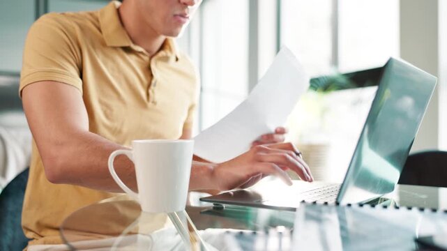 Coffee, documents and laptop with junior accountant in office for administration or bookkeeping. Accounting, computer and finance with assistant bookkeeper in workplace for bank reconciliation