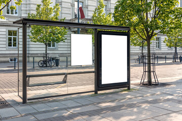 Blank White Bus Stop Billboard Mockup In Front Of An Empty Street. Outdoor Advertising Poster Lightbox On The Sidewalk