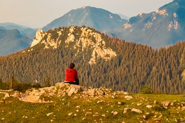 Fototapeta premium Alpine summer evening view with an unknown hiker at Mount Kampenwand, Aschau, Chiemgau, Rosenheim, Bavaria, Germany