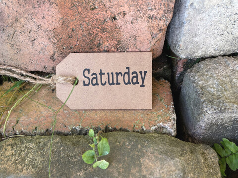 Day, time and calendar concept. Saturday written on wooden tag. On blurred styled background.