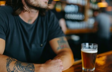 Close-Up of a Tattooed Man Enjoying Beer in a Cozy Bar Setting