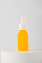 Yellow glass cosmetic bottle, Skin care or sunscreen cosmetic with stylish props on white background.
