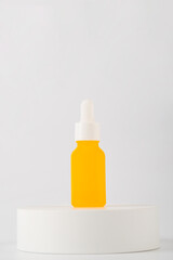 Yellow glass cosmetic bottle, Skin care or sunscreen cosmetic with stylish props on white background.