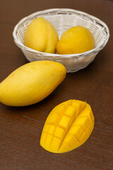 Delicious ripe juicy mangos on wooden table, top view