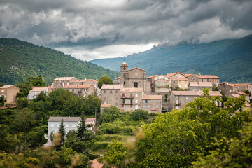 Obraz premium The remote mountain village of Cozzano in the interior of the island of Corsica with pine forests and mountains in the distance