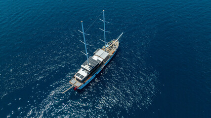 A breathtaking aerial view of a luxurious yacht cruising on the blue waters