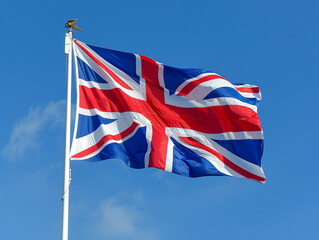Waving Union Jack Flag Against Clear Blue Sky During Bright Sunny Day