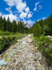 Photo of a stream in Val di Fassa with Sass Pordoi in the background - Italy