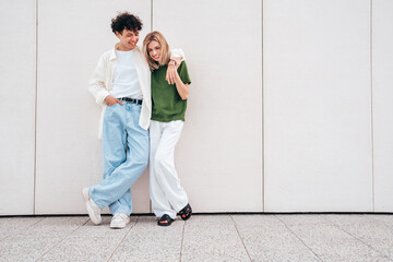 Smiling beautiful woman and her handsome boyfriend. Couple in casual summer clothes. Happy cheerful family. Female and man having fun. They posing in the street in sunny day. Having tender moments