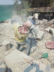 Indian Stone Carving Artists Creating Hindu God Statue Of Stone. Cutting rock with grinder. Stone...