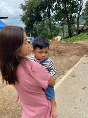 Mother and son enjoying a sunny day at the park, smiling and having fun togethe