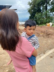 Mother and son enjoying a sunny day at the park, smiling and having fun togethe