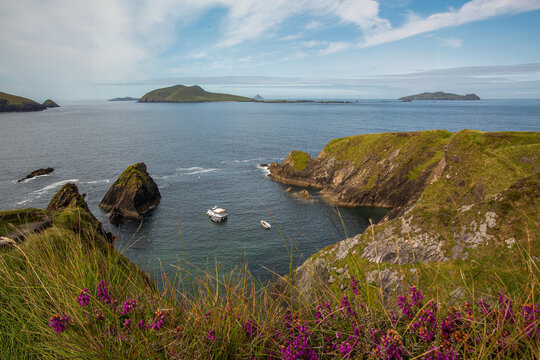 C&eacute; Dh&uacute;n Chaoin / Dunquin Pier in Irland auf der Halbinsel Dingle mit Blick auf die Blasket Inseln. Zwei kleine Boote d&uuml;mpeln im seichten Wasser.