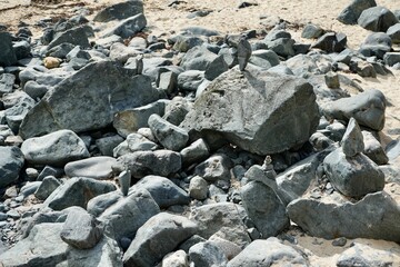 Balanced stones on rocks on a sunny Cornish beach. 