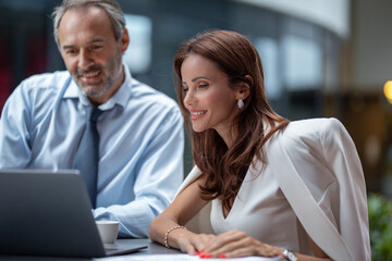 Fototapeta premium Two business people working outdoor with laptop, stock photo