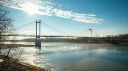 Obraz premium A newly built suspension bridge spanning a wide river, glistening in the sunlight
