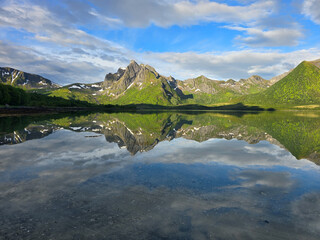 Lush Green Mountains Reflecting in Serene Lake Under a Beautiful Norwegian Sky