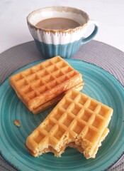 Breakfast with coffee and waffles on the table. Selective focus.