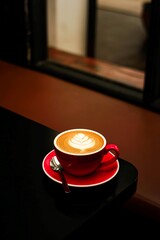 latte coffee drink with red cup on cafe background