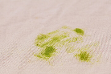 Grass stain on pink clothes. Light pink cotton fabric with a stubborn stain - close-up photo....