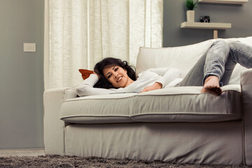 Obraz premium Young woman relaxing on sofa at home