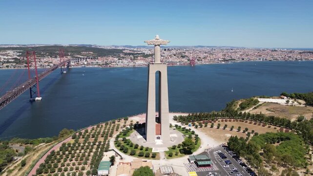 Drone footage of the Sanctuary of Christ the King statue on a sunny day in Almada, Portugal