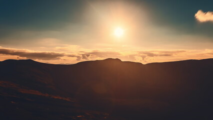 Witness the breathtaking transformation of light as the sun sets over the stunning Carpathian Mountains, casting warm hues across the expansive landscape.