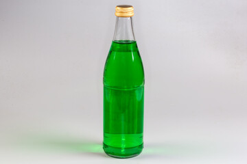 Green non-alcoholic carbonated drink in the closed glass bottle