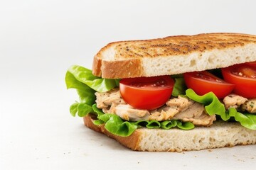 Chicken, lettuce, and tomato sandwich over a white background