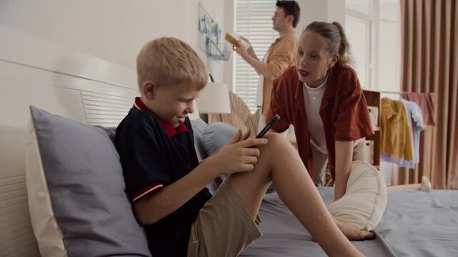 Caucasian mother forbidding her teenage son to play with tablet pc all day at home