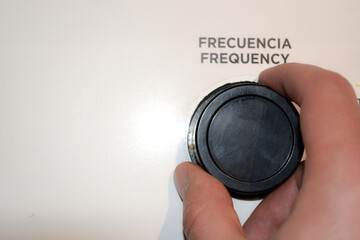 Close-up of a woman's hand holding a frequency control lever. White advertising background, frequency control button mockup.