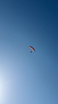 Man paragliding on a sunny day.