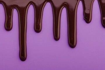 Close-up of dark chocolate drips on a purple background, emphasizing contrast and texture.