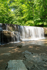 Naklejka premium A beautiful view of a waterfall hidden away in a lush and green forest.