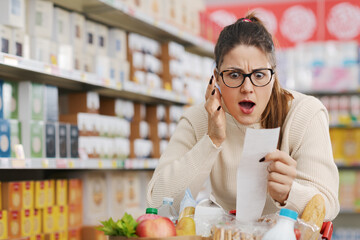 Woman checking an expensive grocery receipt at the supermarket