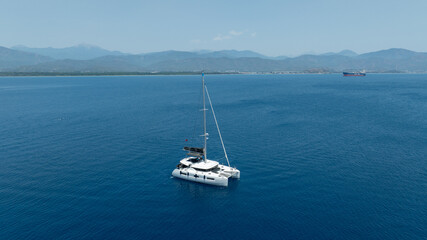 Fototapeta premium Overhead capture of a catamaran cruising under the sunny sky.
